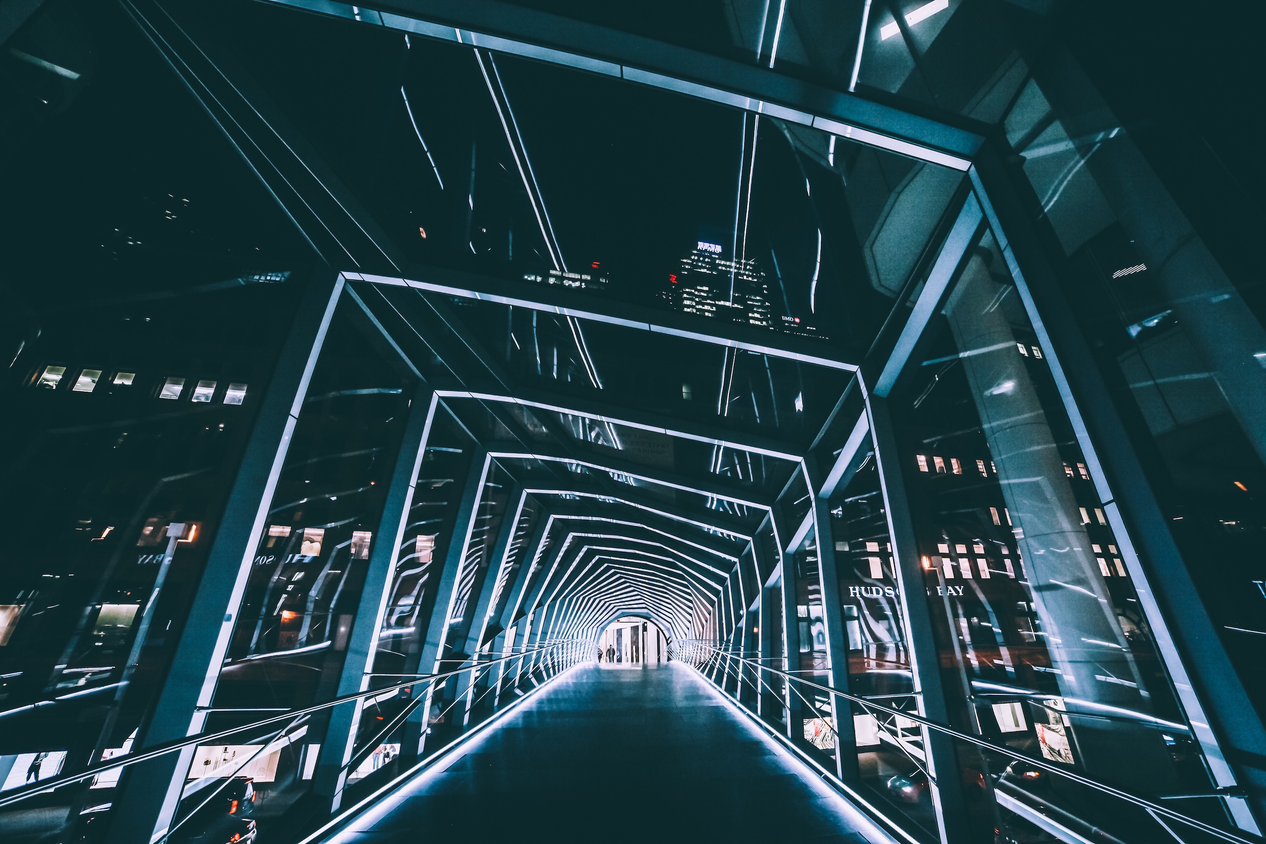 Passerella vetrata illuminata tra due edifici, vista in prospettiva